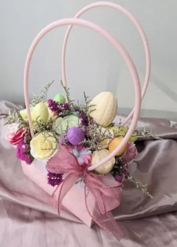 Rosa gavekurv med påskeegg-lys og blomster